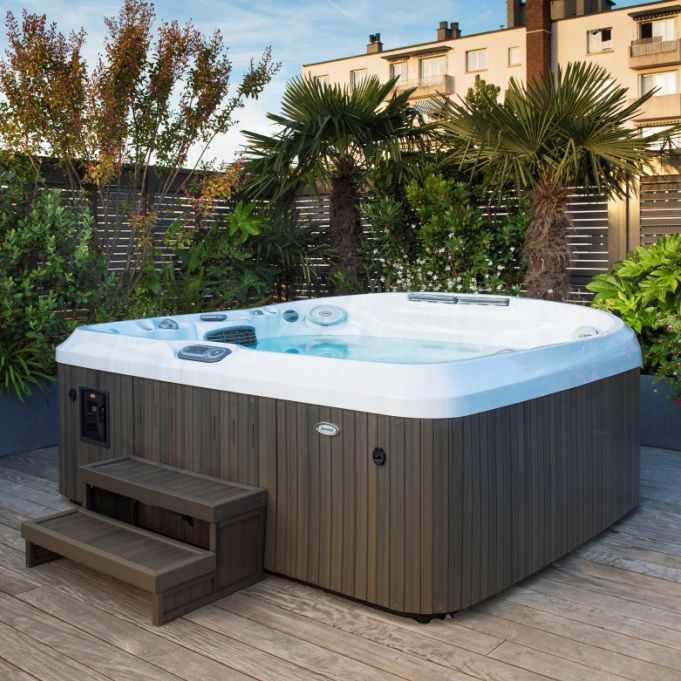 Outdoor jacuzzi with a white spa interior and steps on a wooden deck